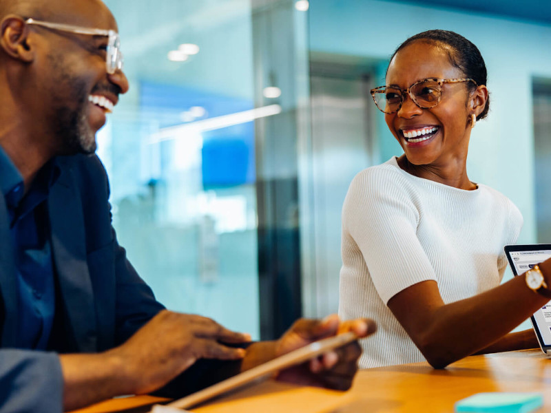Two peopling talking at a desk